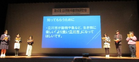 写真:スクリーンをはさんで両脇に並ぶ子ども