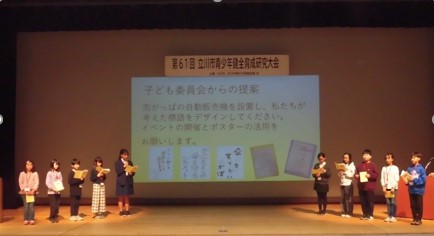 写真：スクリーンをはさんで両脇に並ぶ子ども