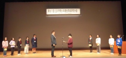 写真：子どもが市長へ提案書を渡す様子