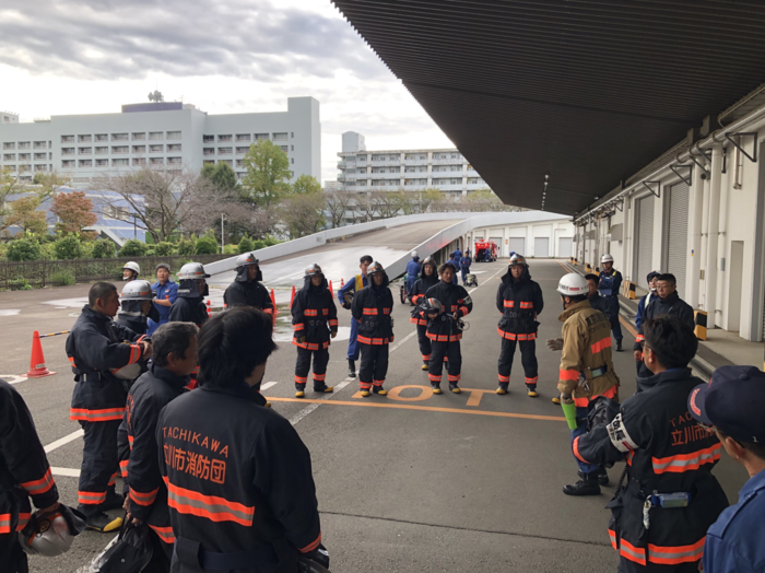 消防署員から消防団員が講評を受けている様子