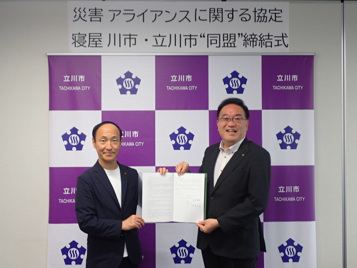 寝屋川市長と立川市長が協定書を持って並んだ写真
