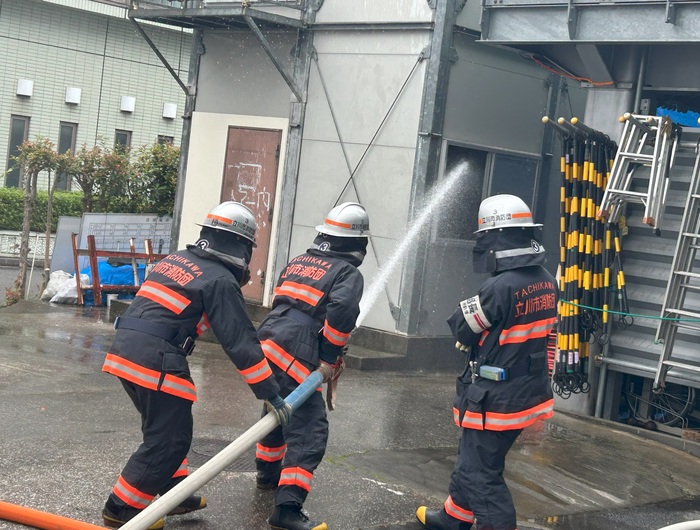 立川市消防団員が放水している様子を近くから写したもの