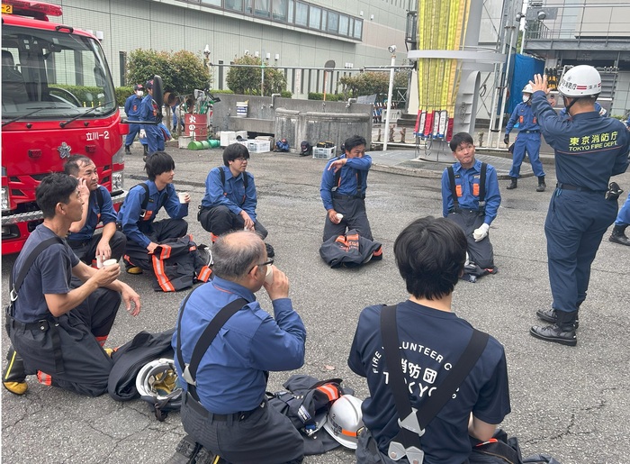 消防署員から消防団員が講評を受けている様子