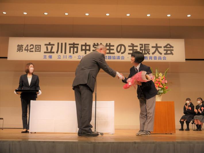表彰式で西川さんは市長から花束を受け取りました。