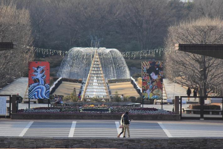 昭和記念公園の噴水前を若い男女が歩いている写真