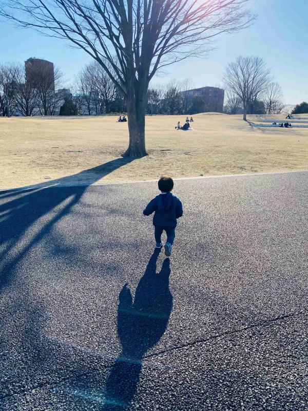 公園で走る男の子の後ろ姿の写真