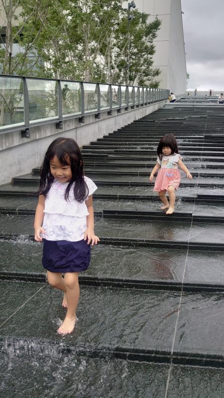 水が流れる階段をはだしで歩く姉妹の写真